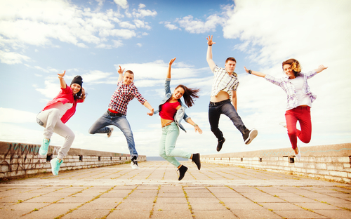 summer, sport, dancing and teenage lifestyle concept - group of teenagers jumping